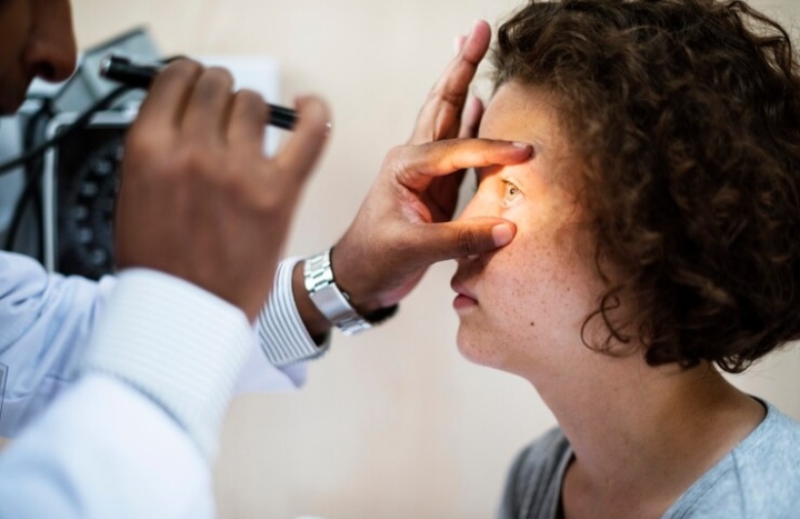 Optometrist examining a patient for dry eyes with a slit lamp