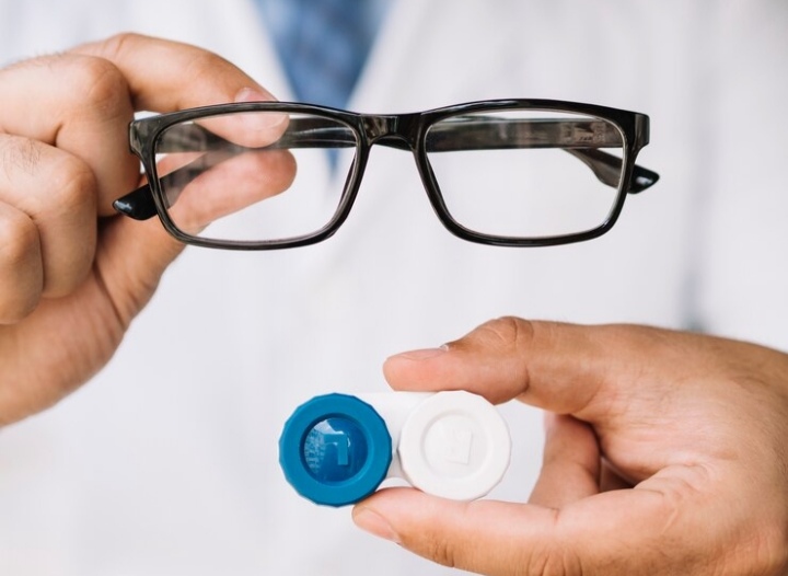 ptometrist fitting a contact lens on a patient's eye.